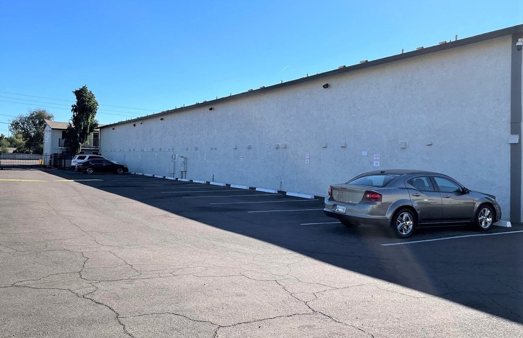 the side of a building with cars parked in a parking lot