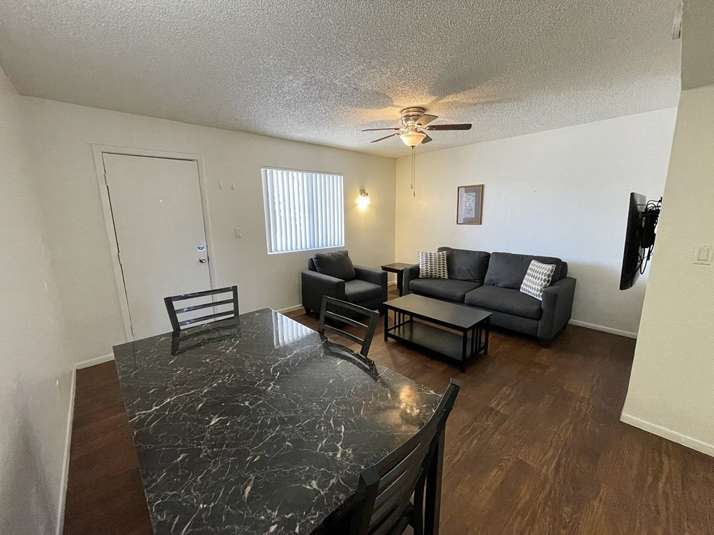 a living room with couches and a table and a ceiling fan
