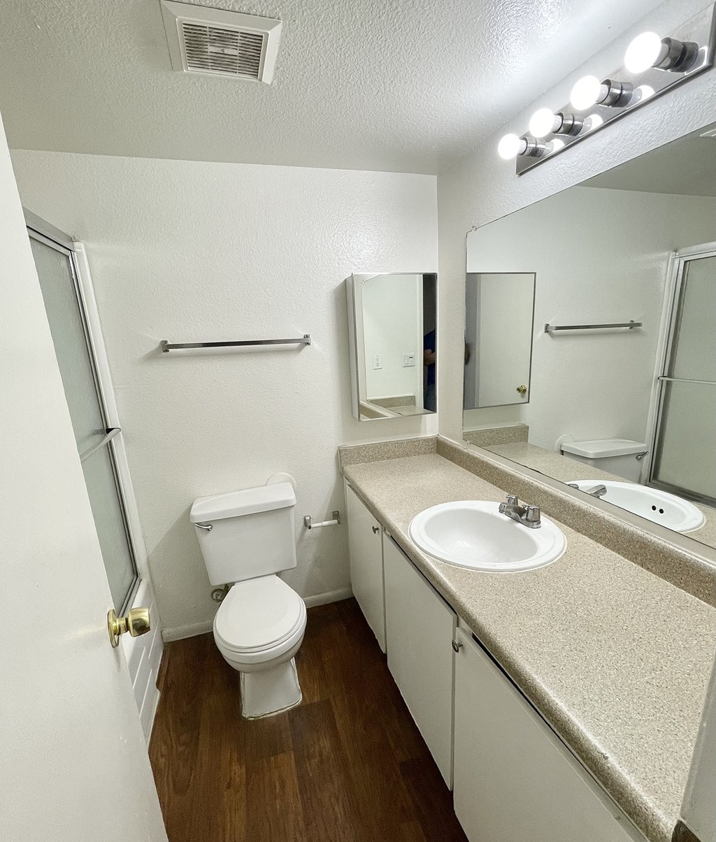 an empty bathroom with a sink toilet and mirror