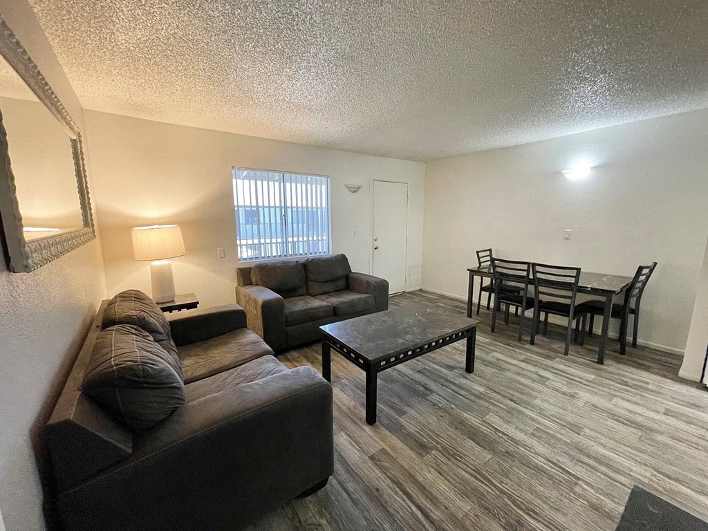 the living room and dining room of an apartment with a couch and a table