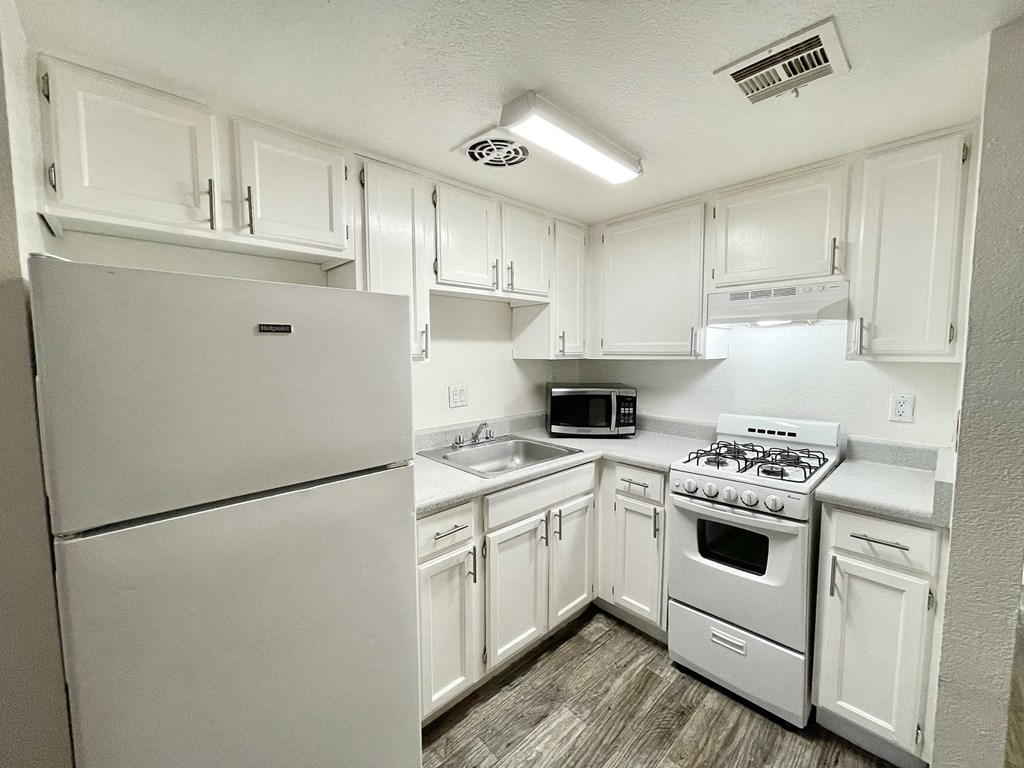 a kitchen with white appliances and white cabinets