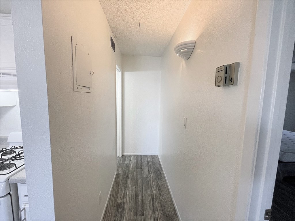 an empty hallway with white walls and wood floors