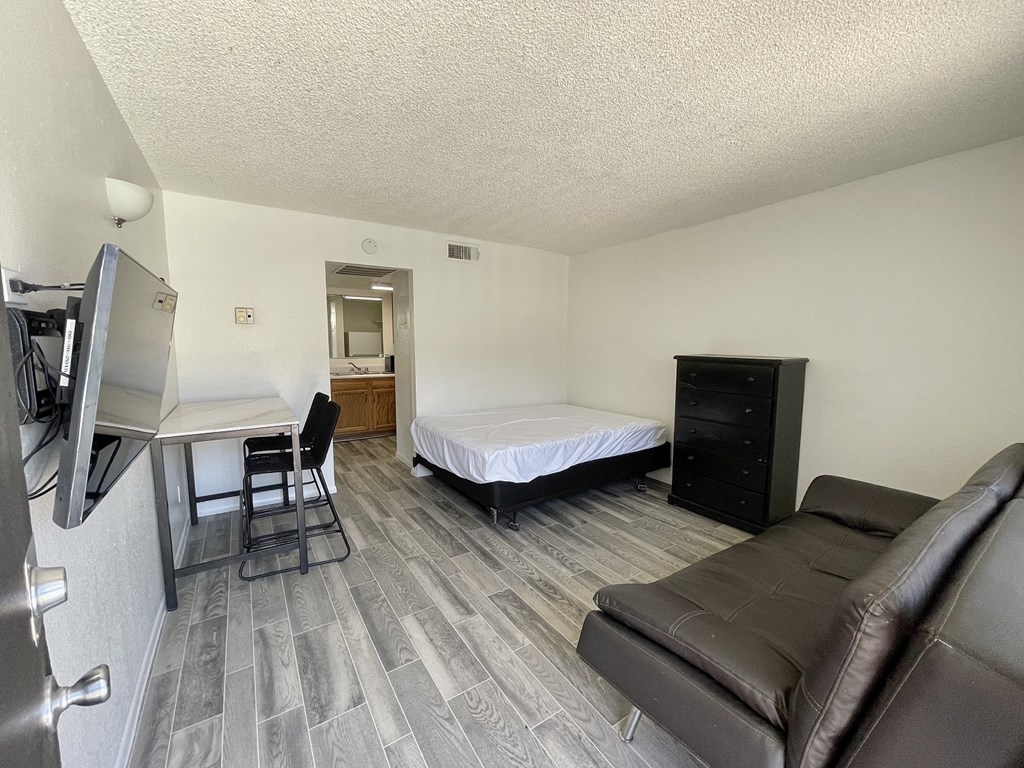 a small room with a couch and a desk and a bed