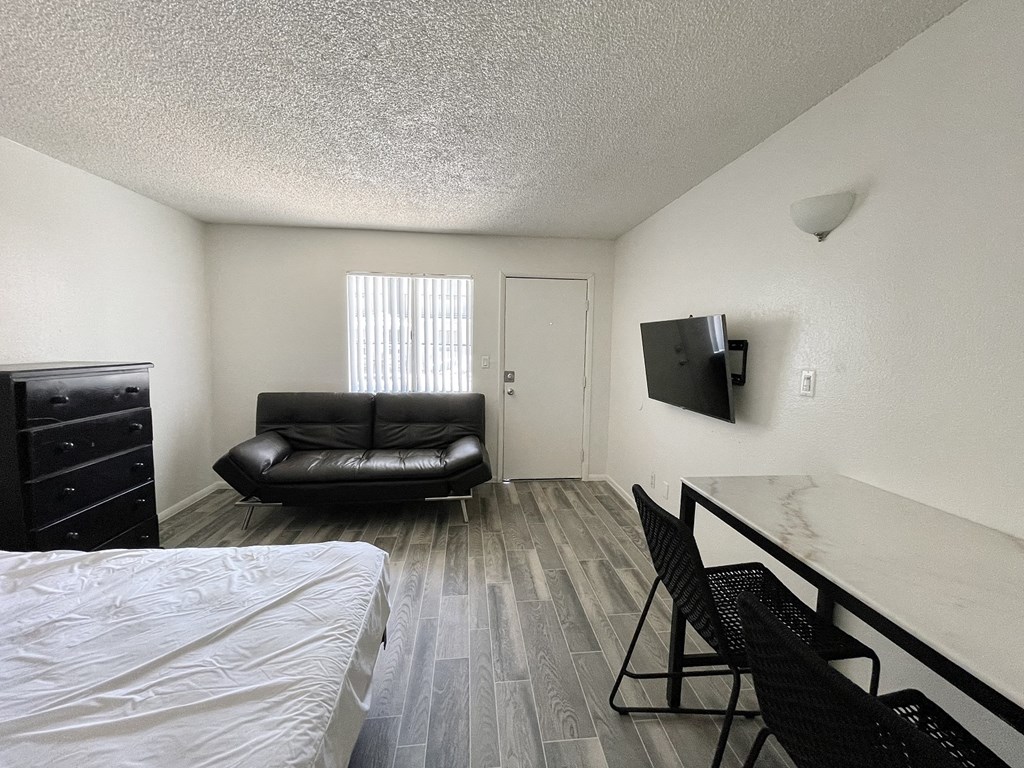 a bedroom with a couch and a table and a tv