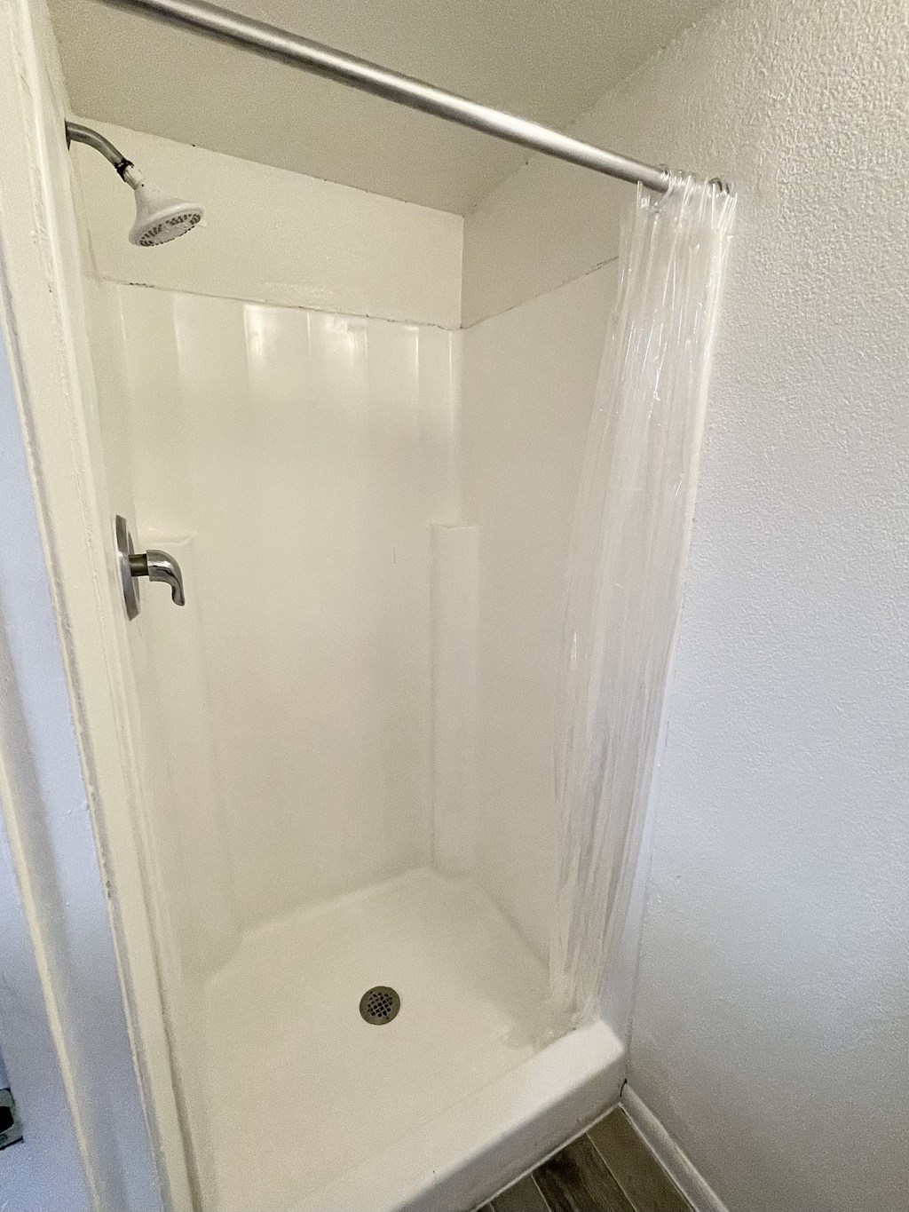 an empty shower in a bathroom with a shower curtain
