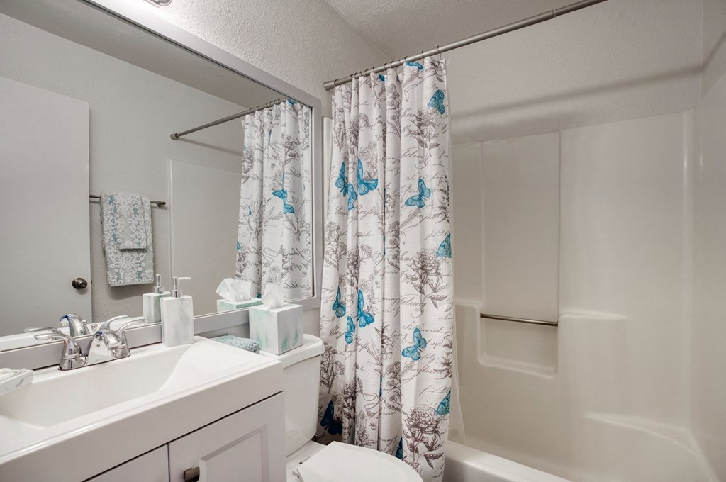 a bathroom with a shower curtain and a sink and a toilet