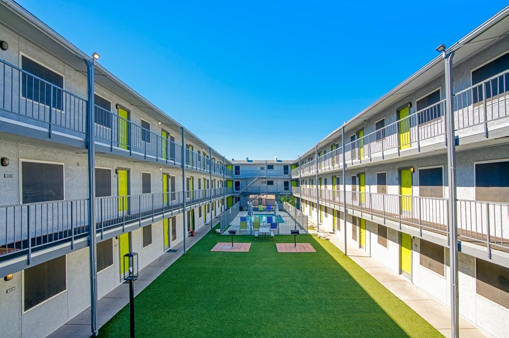 a courtyard with green grass and a pool in a building