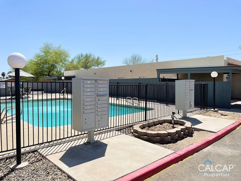 a swimming pool in front of a building with a fence