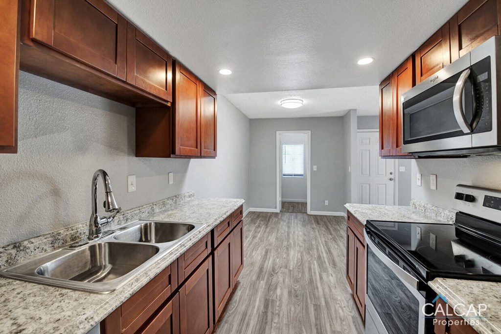 a kitchen with a sink and a stove and a microwave