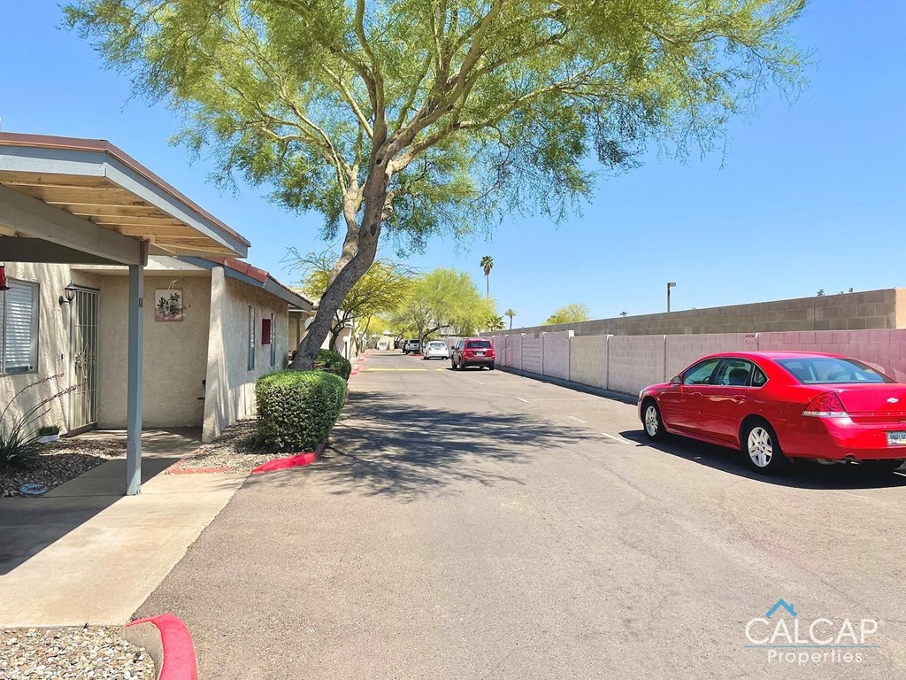 a parking lot with a red car parked in front of a building