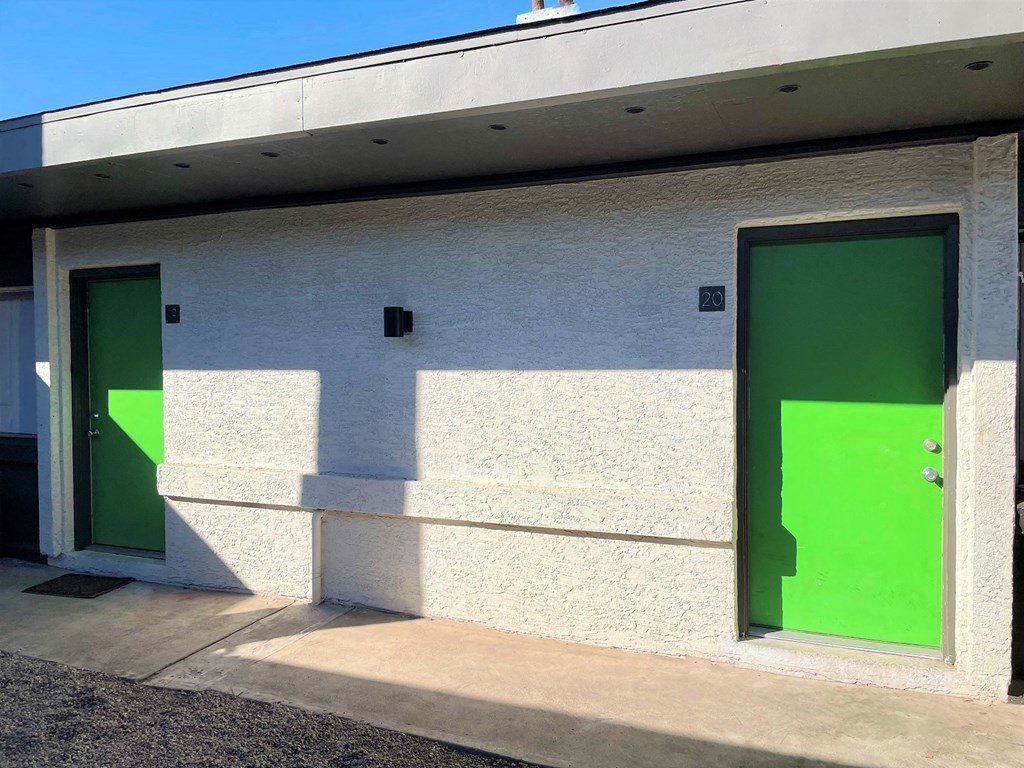 two green doors on the side of a building