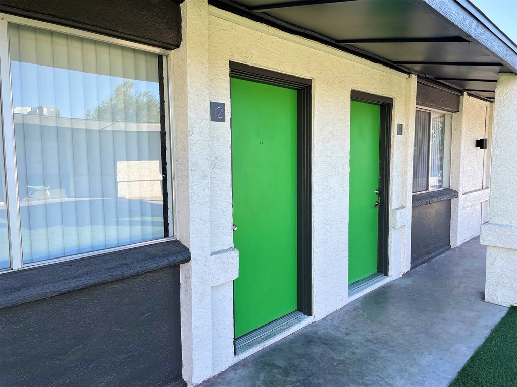 two green doors on the side of a building