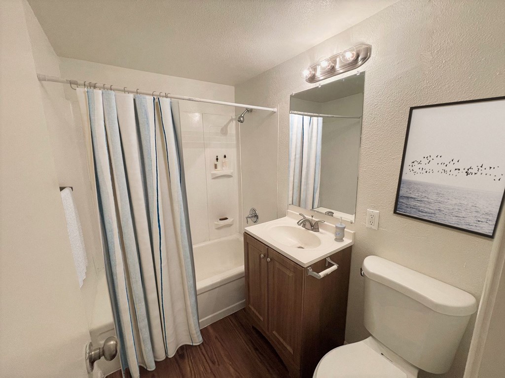 a bathroom with a toilet sink and shower in a 555 waverly unit