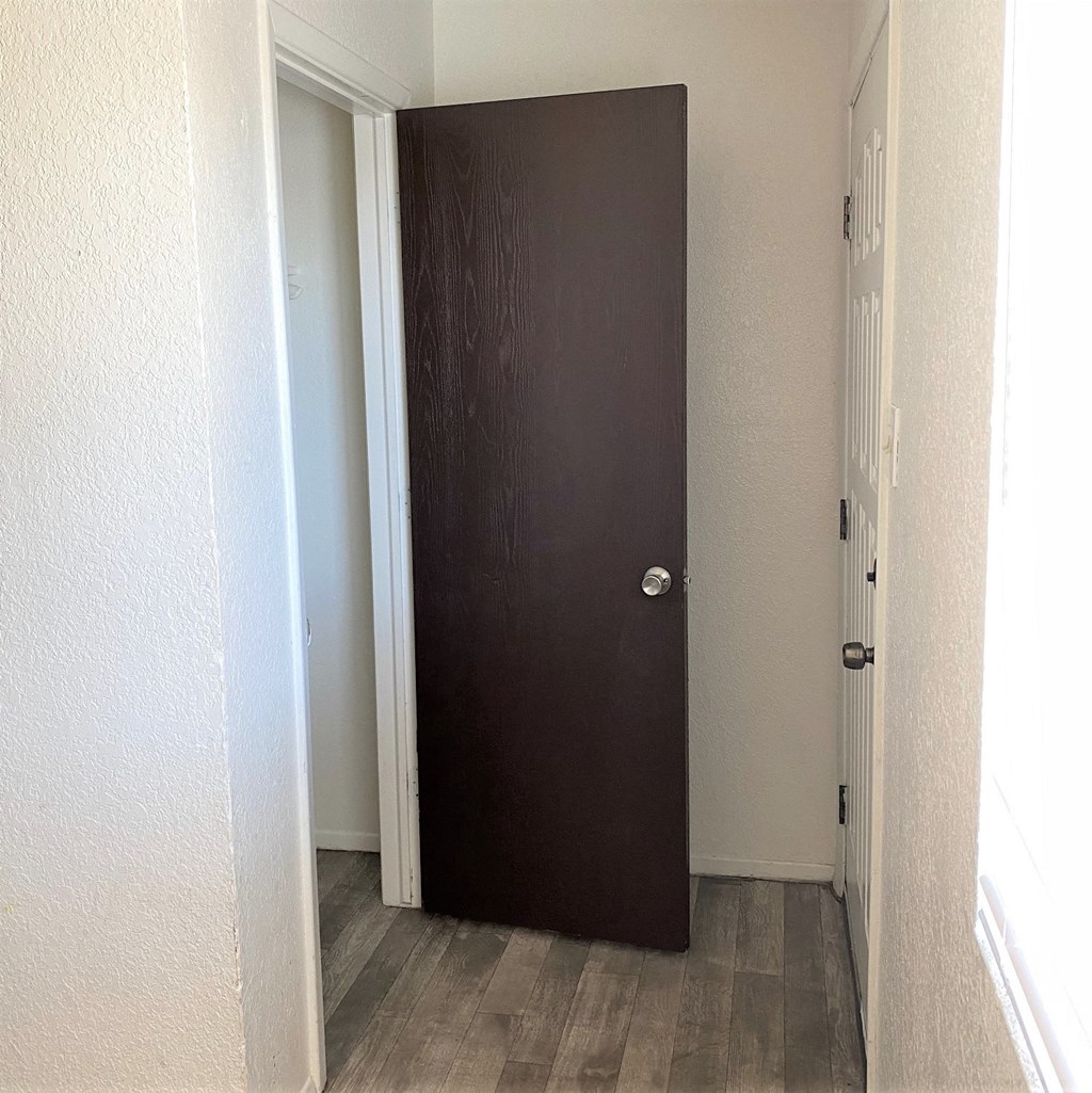 a brown door in a hallway with a door to a closet