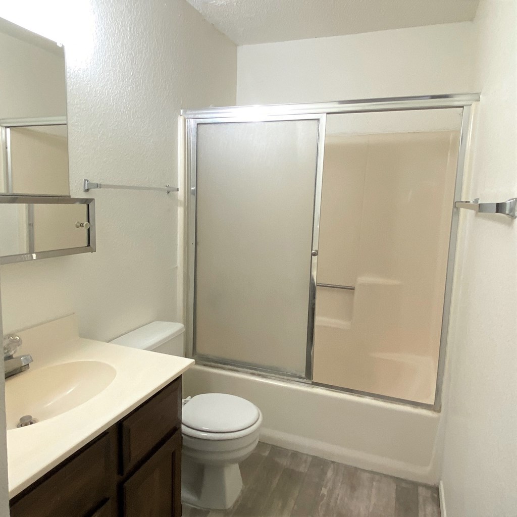 an empty bathroom with a shower toilet and sink
