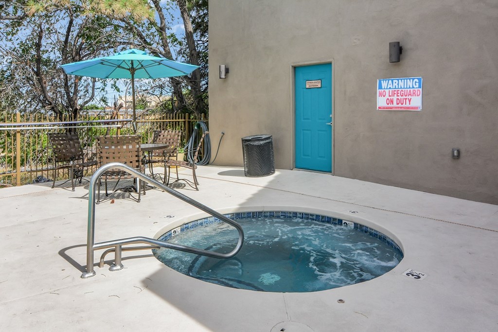 the jacuzzi pool at our apartments has a blue door and an umbrella