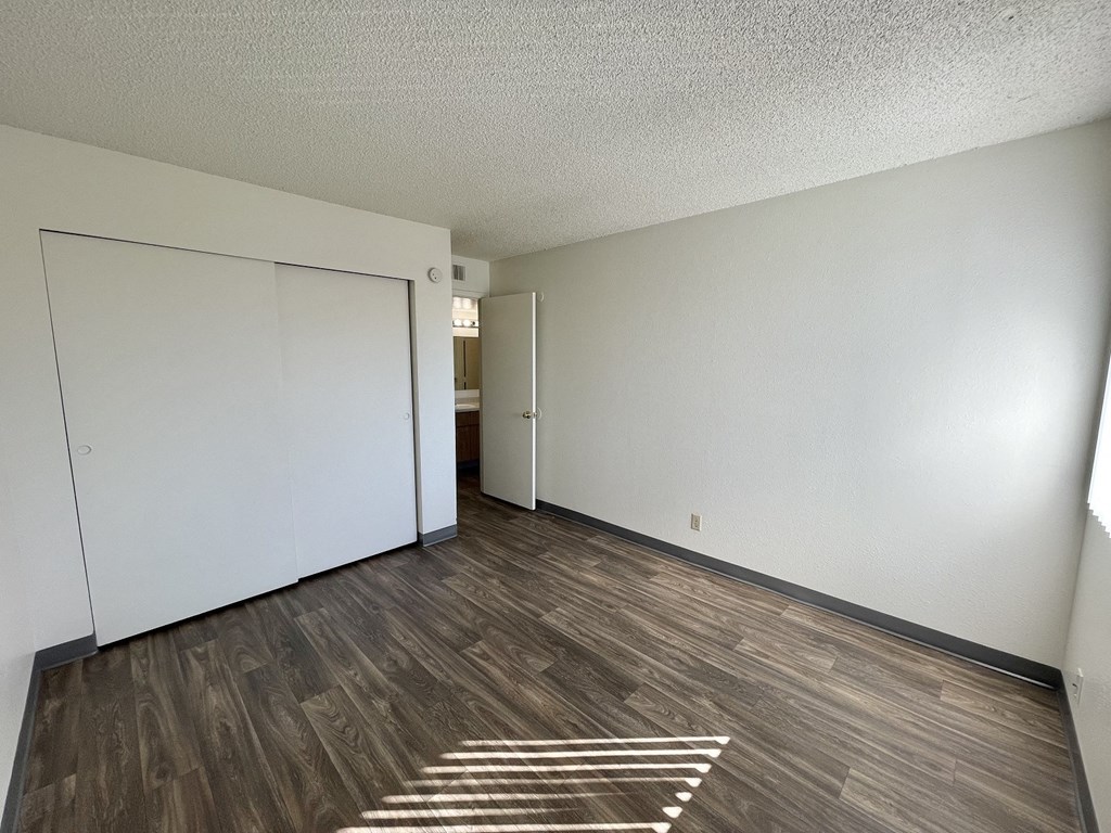 an empty living room with white walls and wood flooring