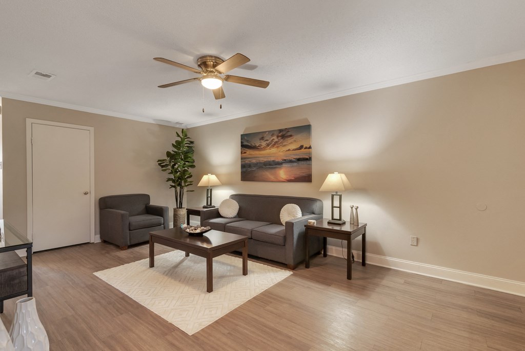 an empty living room with couches and a ceiling fan
