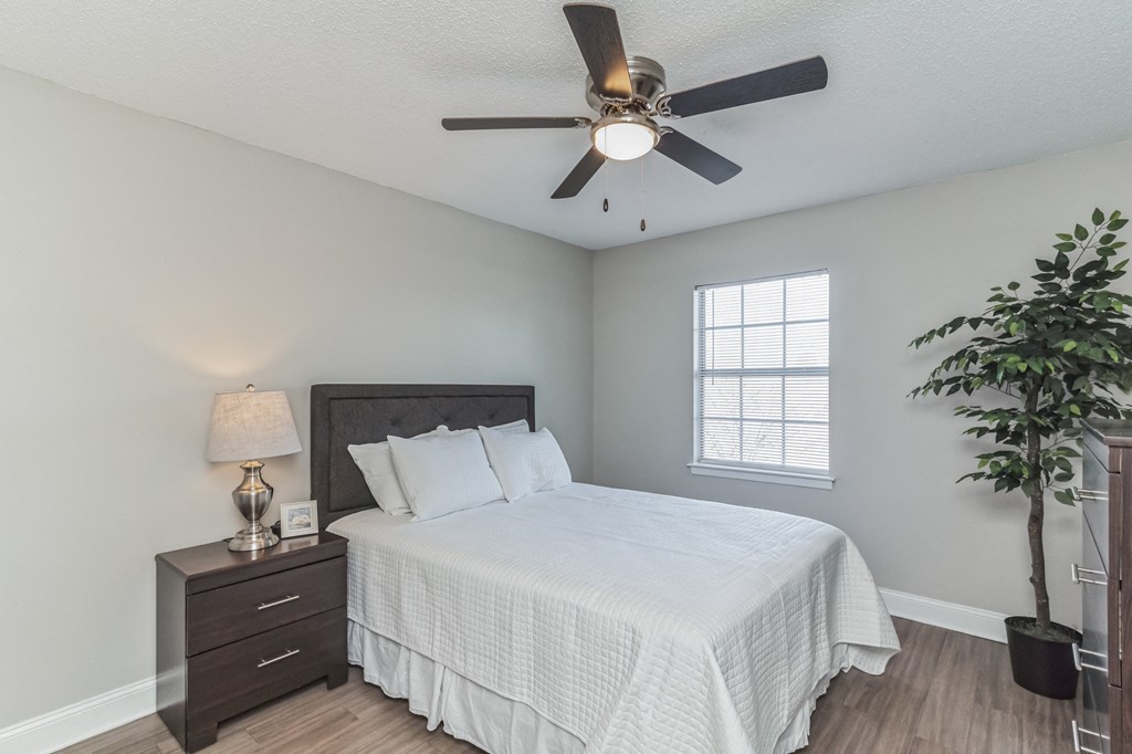 a bedroom with a large bed and a ceiling fan