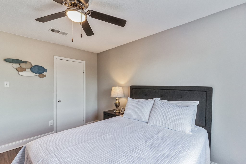 a bedroom with a bed and a ceiling fan