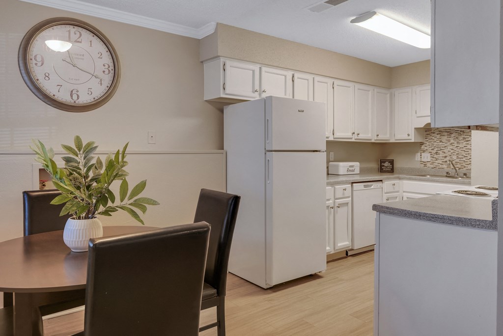 a kitchen and dining room with a large clock on the wall