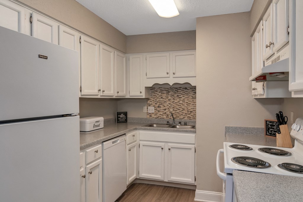 a kitchen with white cabinets and appliances and a white refrigerator