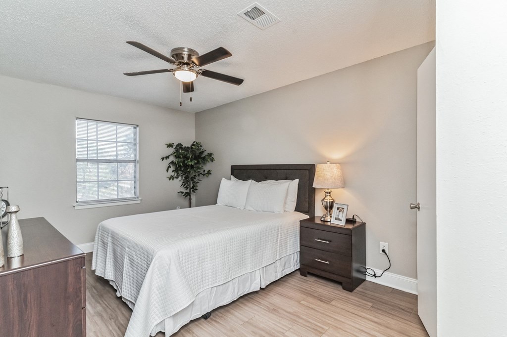 a bedroom with a large bed and a ceiling fan
