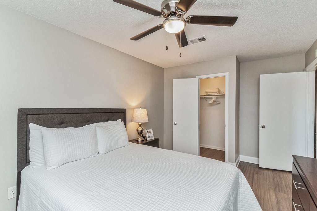 a bedroom with a large bed and a ceiling fan