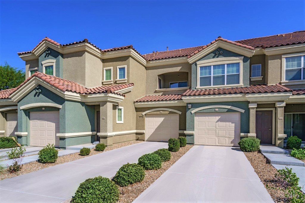 an image of a house with a driveway and garage doors