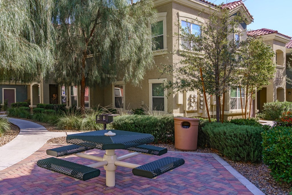 a courtyard with tables and benches in front of an apartment building