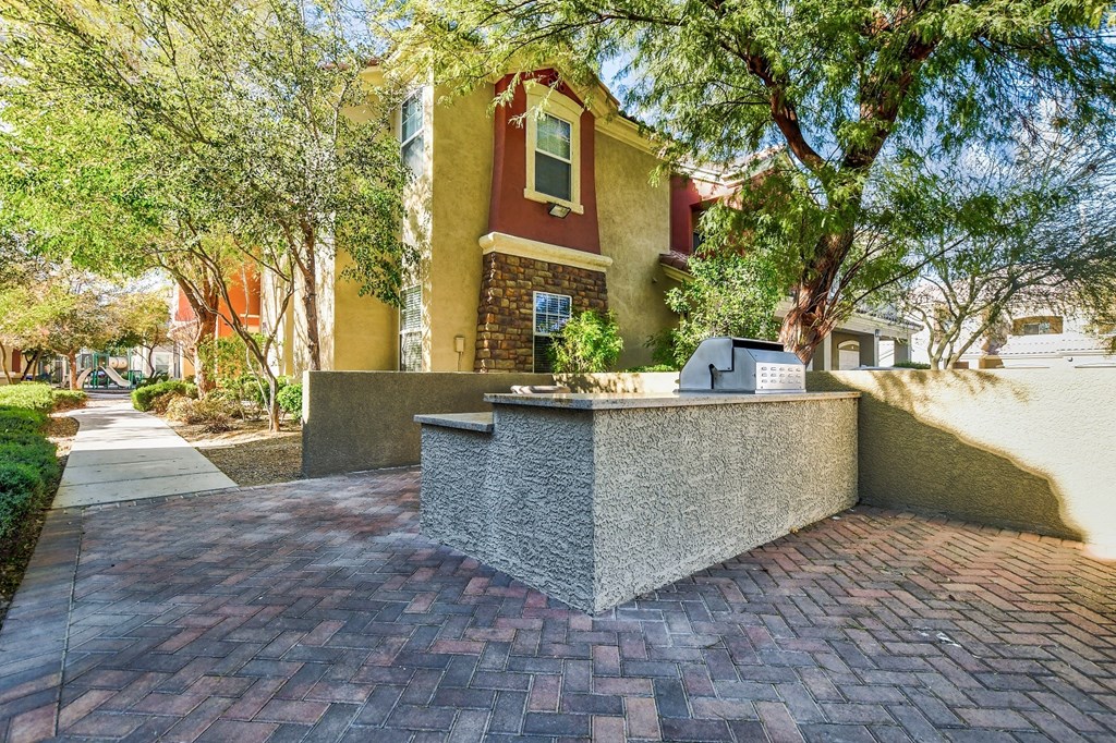 a brick sidewalk with a fountain in front of a house