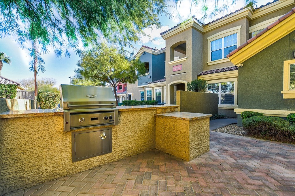 a backyard with a barbecue grill in front of a house