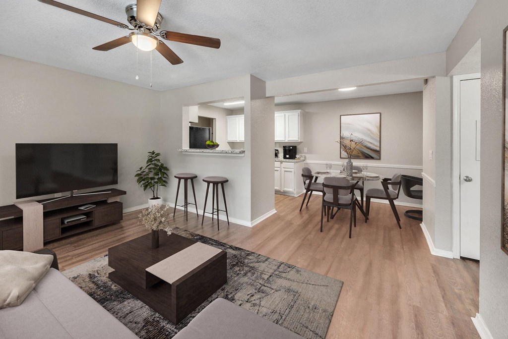 an open living room and dining room area with a tv and a table and chairs