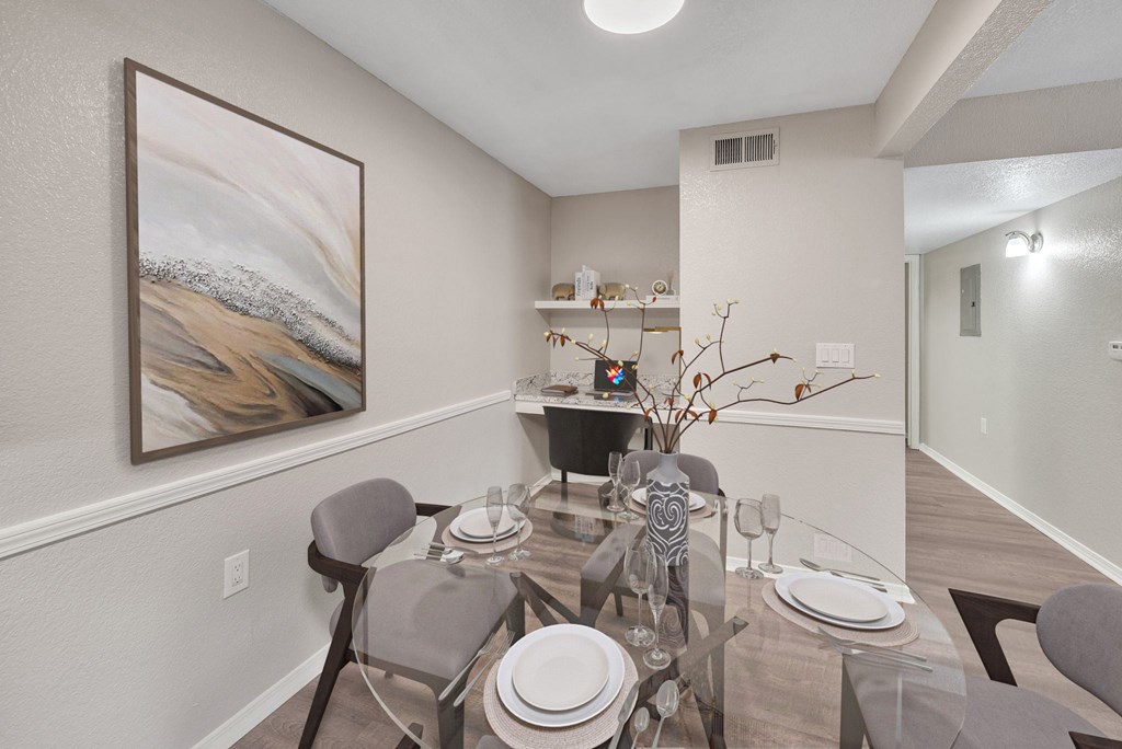 a dining room with a glass table and chairs