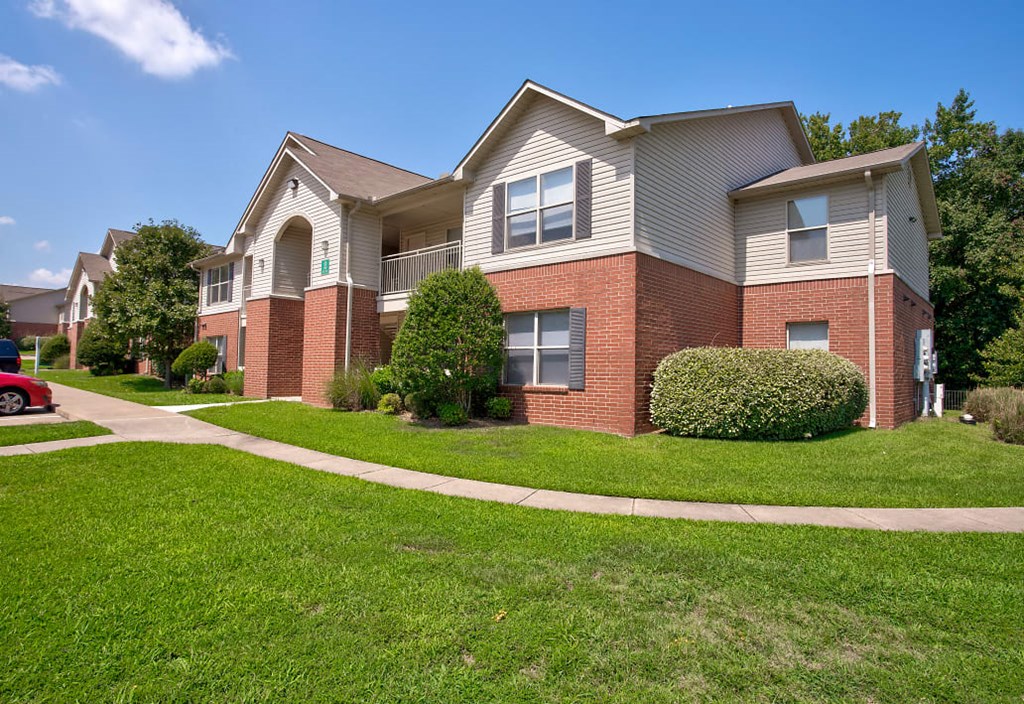 a brick house with a sidewalk in front of it