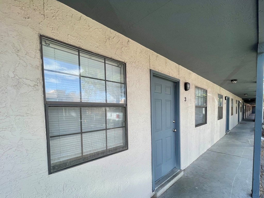 an empty building with a blue door and window