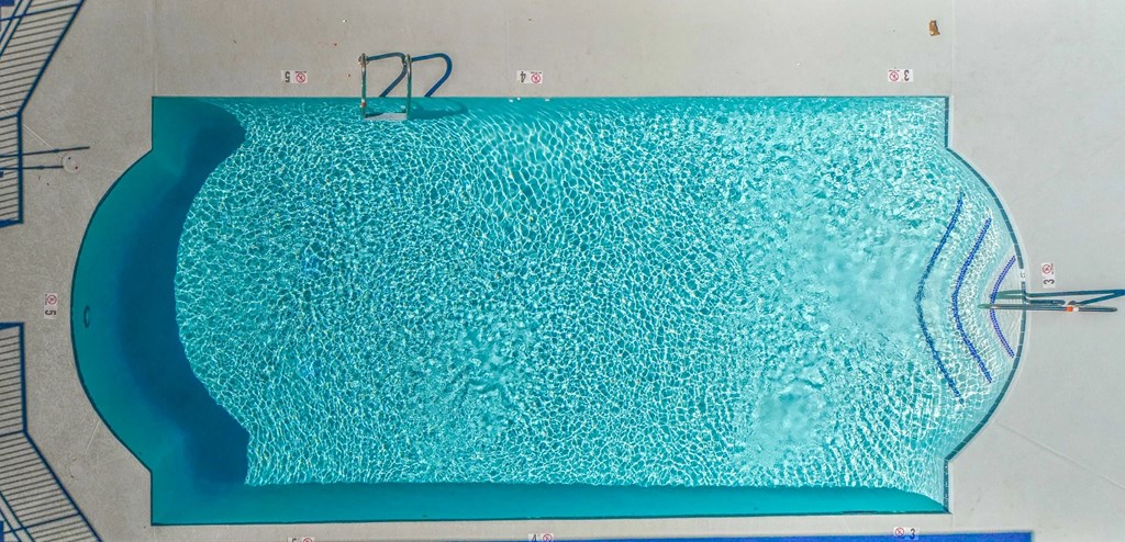 a large blue pool with a pair of glasses in it