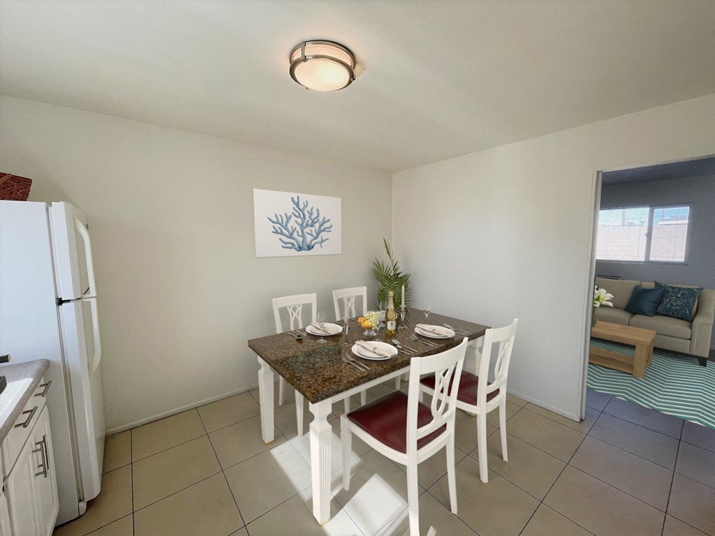a dining area with a table and chairs and a refrigerator