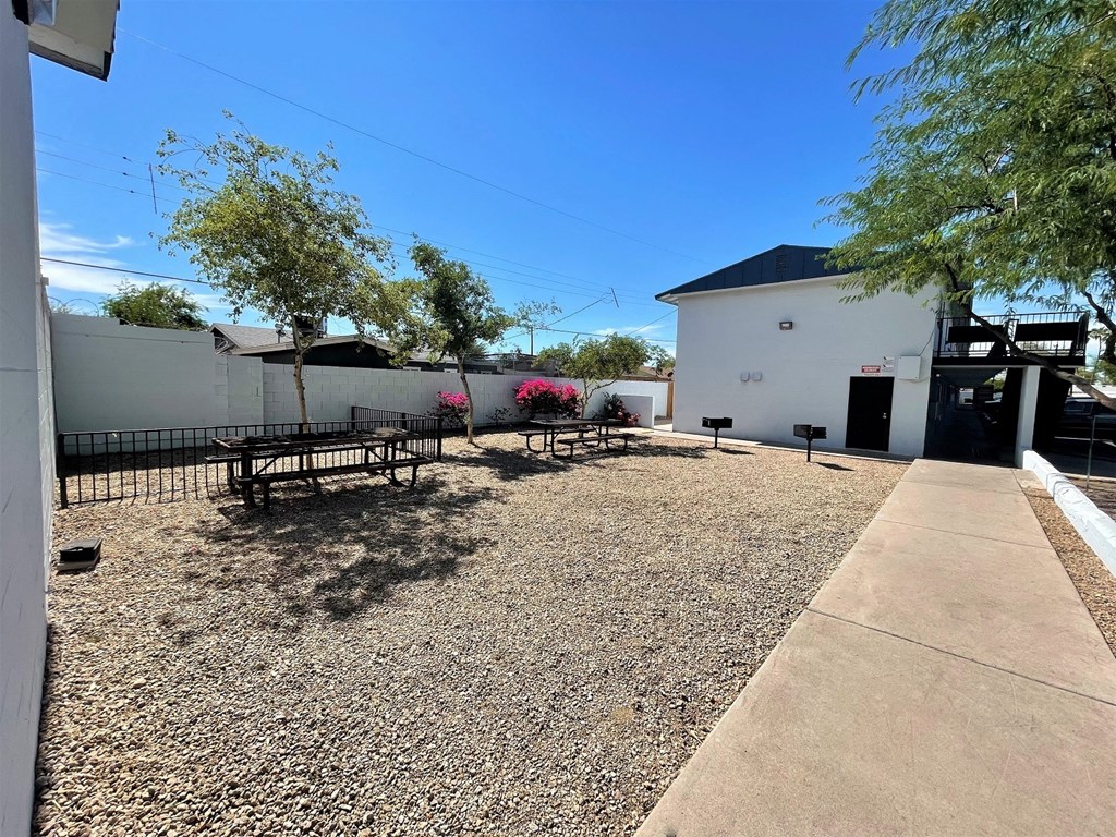 a courtyard with benches and trees in front of a building