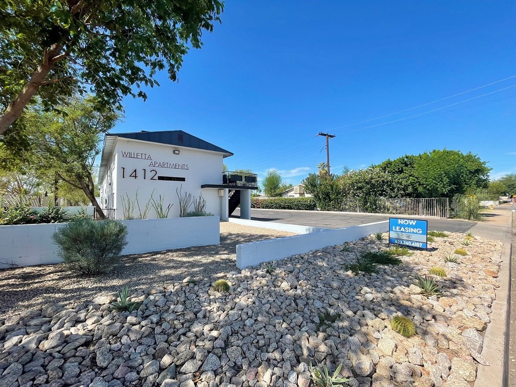 a white building with a blue sign next to a road