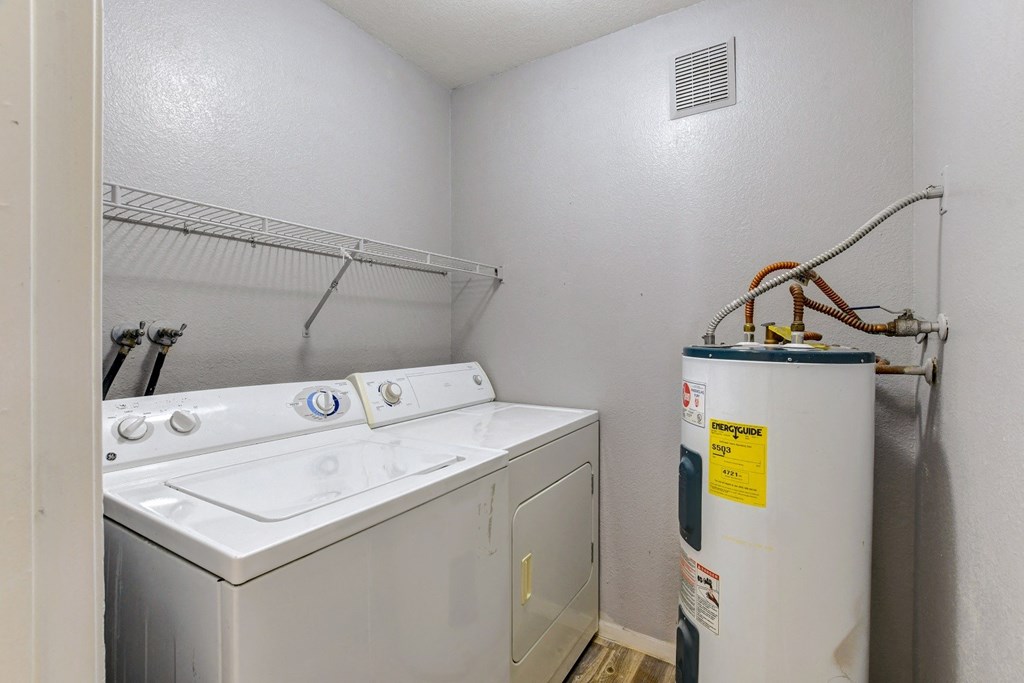the laundry room has a washer and dryer and a water heater