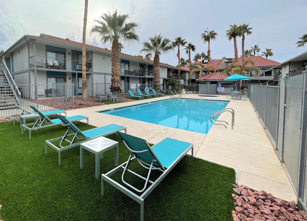 a resort style pool with lounge chairs and palm trees