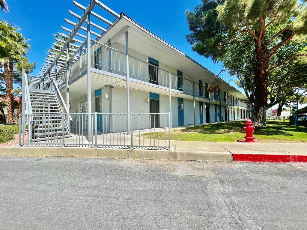 a white building with a red fire hydrant in front of it