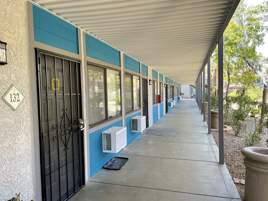 a long porch with doors and windows on the side of a building