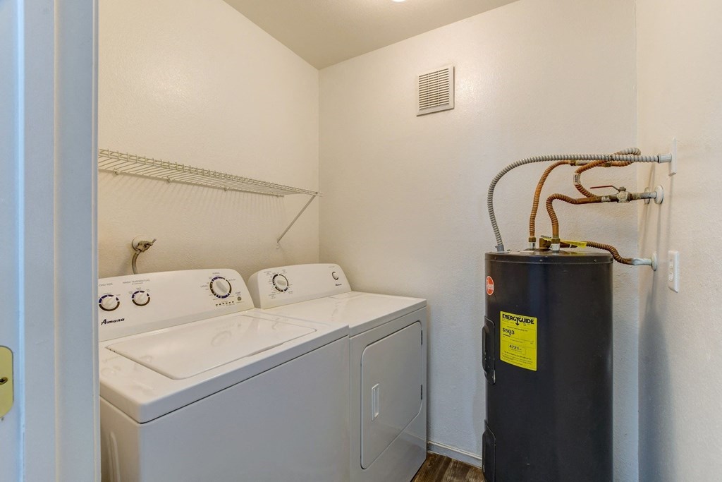 the laundry room has a washer and dryer and an airconditioning unit