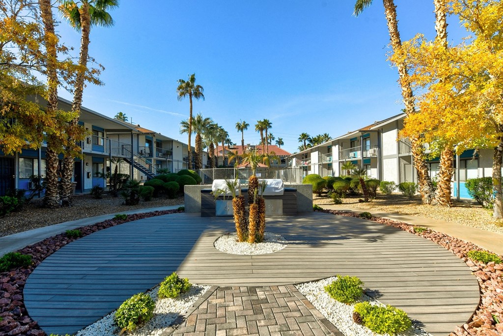 a courtyard with a fountain and trees in front of apartment buildings