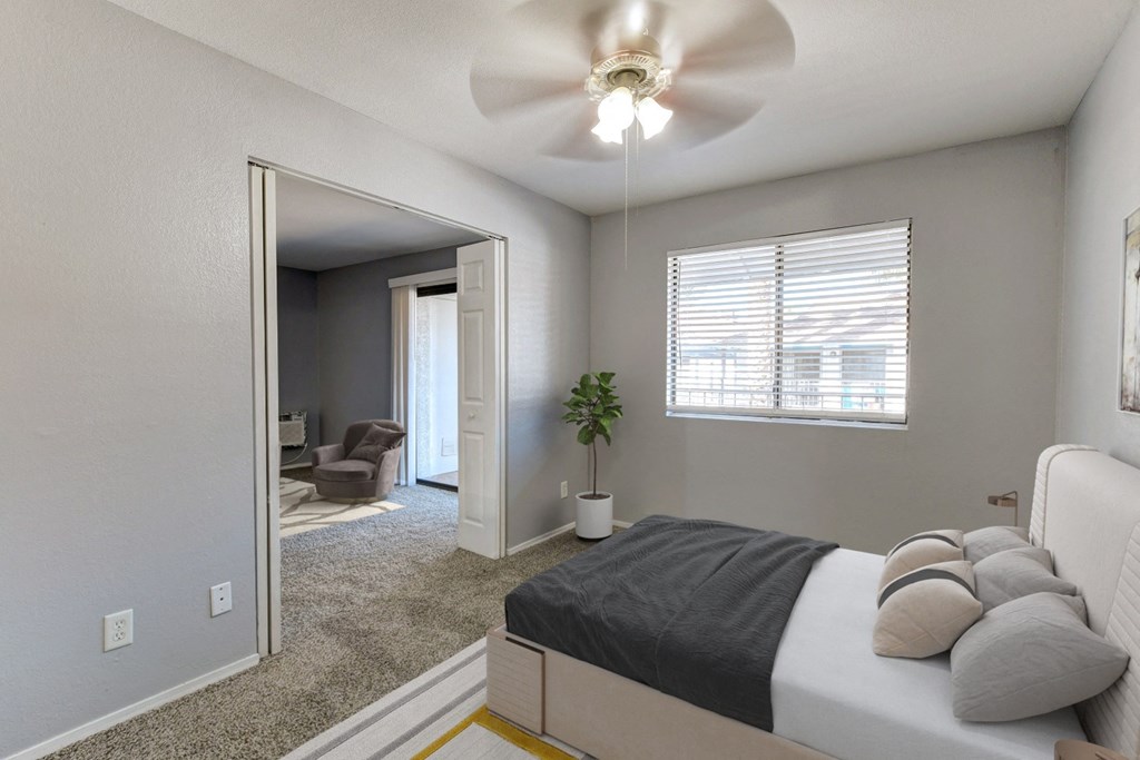an empty bedroom with a bed and a ceiling fan