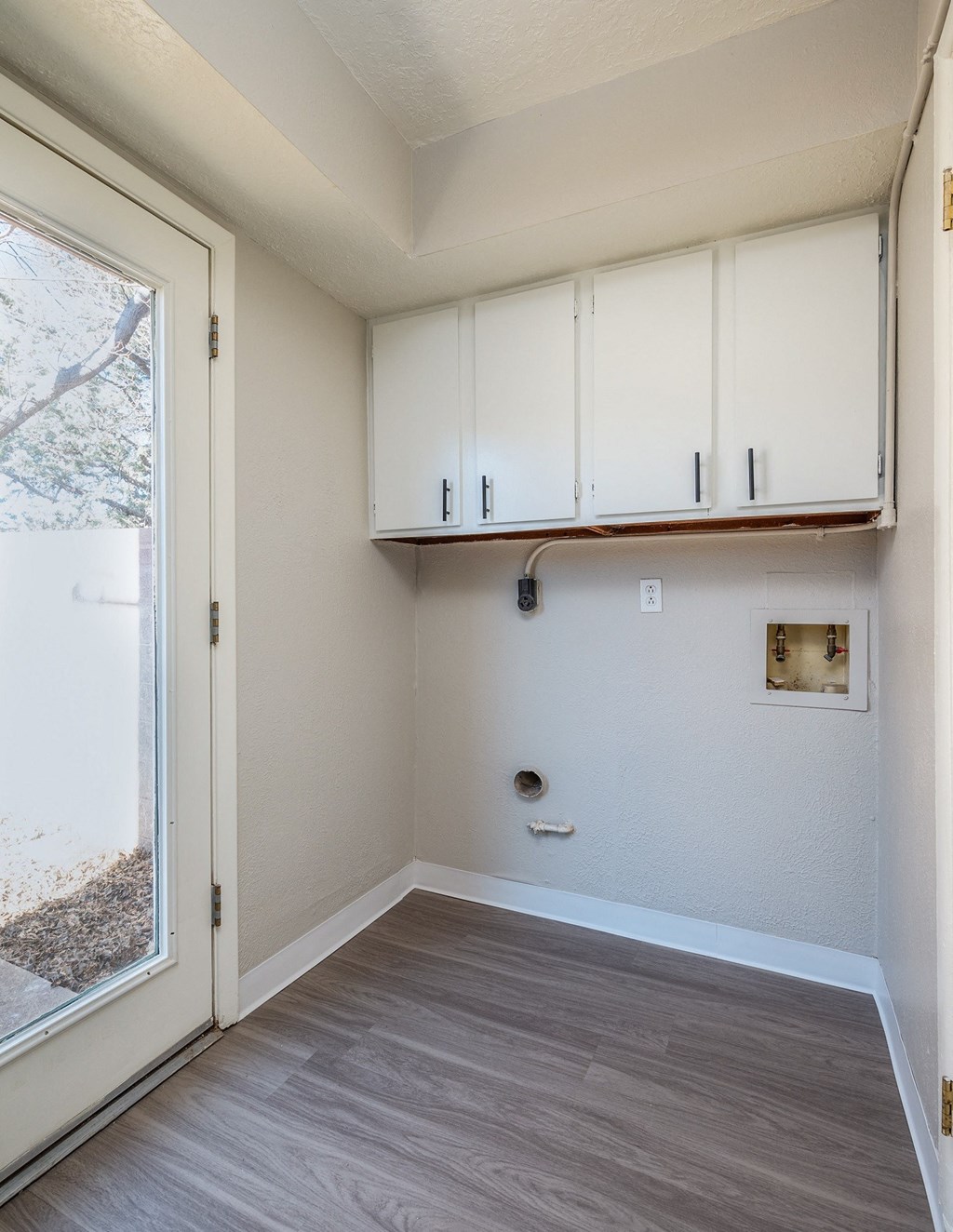 an empty room with white cabinets and a window