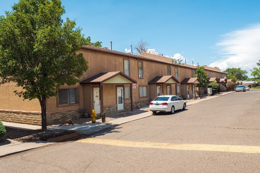 a row of brown buildings with a white car parked in front of them