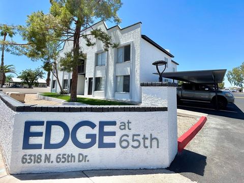 a large white building with a sign that says edge at 65th